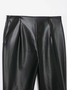 Detailed close-up of high-waist black faux leather pants featuring a side hidden zipper