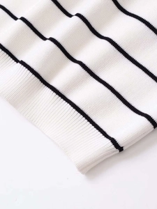 Detail of white knit top with black stripes showing fine ribbed texture and premium stitching