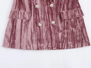 Close-up of pink velvet fabric detail with silver buttons and flap pockets texture
