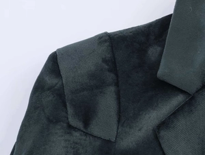 Gros plan du revers d'un blazer en velours montrant la texture du tissu et les coutures nettes