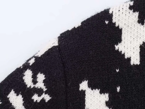 Close-up of black and white jacquard knit fabric showing wool blend texture and seams
