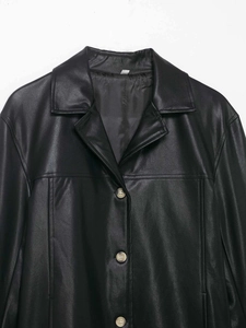 Detail shot of black faux leather jacket collar and amber-textured vintage buttons