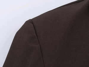 Close-up of shoulder stitching and fine fabric texture on dark double-breasted blazer