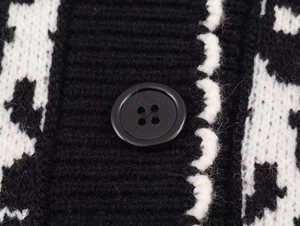 Macro shot of knitted fabric texture and black four-hole button on the winter jacket