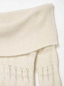 Vue macro détaillée d'un haut en maille blanc cassé avec tissage ajouré sophistiqué