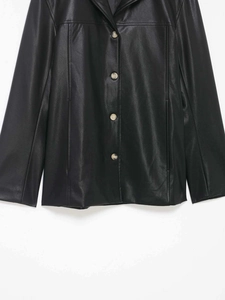 Detail of a minimalist black PU leather jacket with wood-textured single-breasted buttons