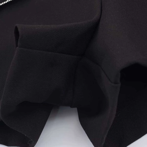 Détail rapproché du tissu noir plissé et des coutures fines du short-jupe de mode