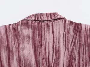 Macro detail of dusty pink velvet pleated fabric showing texture and shoulder stitching