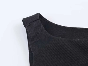 Detailed macro view of black textured fabric straps and fine stitching on a camisole top