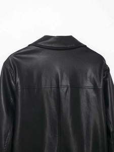 Macro shot of black PU leather jacket back with detailed texture and tailored stitching