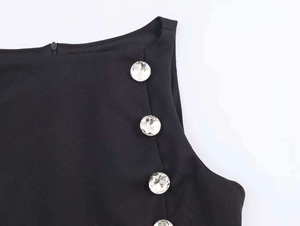 Detail of elegant black top with sparkly rhinestone buttons on the shoulder