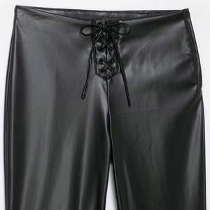 Women's black faux leather flare pants with stylish lace-up waist detail on white background