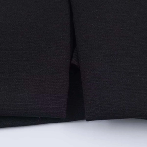 Macro shot of the slit detail and woven texture on a black V-neck sleeveless dress