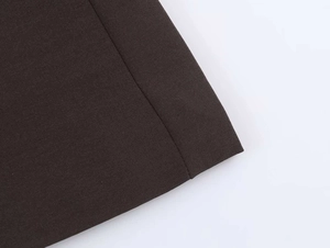 Detail view of deep brown fabric with precise stitching and fine plain weave texture