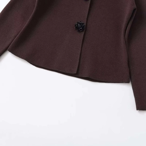 Dark brown knit cardigan featuring detailed black floral buttons and fine texture