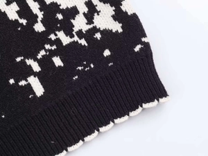 Close-up of black and white jacquard knit texture and ribbed hem on winter sweater