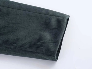 Détail du poignet de blazer en velours vert foncé montrant la texture et les coutures fines