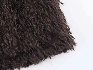 Macro detail of dark brown faux fur texture and dense fiber material on the winter coat
