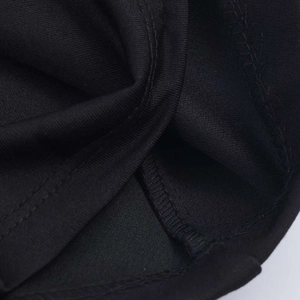 Close-up of high-quality stitching and seam details on the black sleeveless V-neck dress