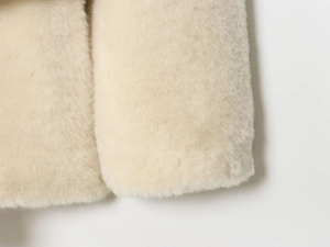 Detail of soft cream faux fur texture on sleeve cuff with premium plush finish