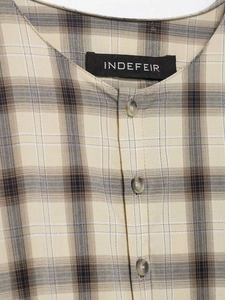 Detail of the woven neckline tag and brown buttons on the beige plaid fashion dress