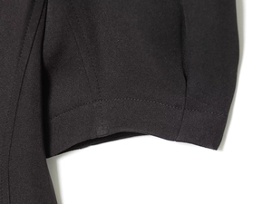 Detailed macro view of black pleated dress fabric with high-quality hem stitching