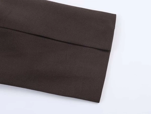 Detailed view of dark brown woven blazer fabric with professional stitched cuff edges