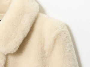 Detail of elegant faux fur coat collar showing ivory plush texture and smooth material finish