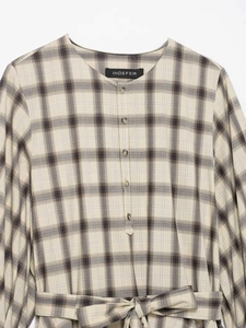 Close-up of beige plaid dress featuring round neck, button front and waist belt detail