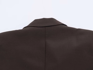 Detailed close-up of dark brown blazer collar with high-quality woven fabric texture