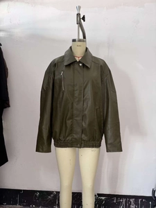 Detail of olive green faux leather bomber jacket featuring lapel collar and zip pockets