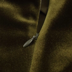 Detail of olive green velvet fabric showing seamless invisible zipper and texture