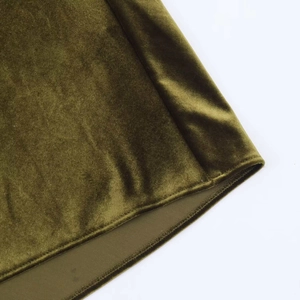 Close-up of olive green velvet dress hem showing premium stitching and fabric texture