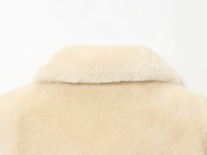 Close-up of the dense and soft beige faux fur texture on an elegant winter coat collar