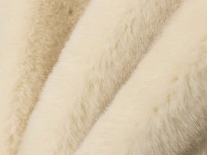 Macro texture of soft cream faux fur fabric on an elegant autumn coat with natural gloss