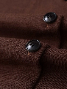 Macro shot of dark brown knit fabric texture and elegant black round four-hole buttons
