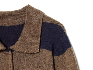 Detail of the polo collar and striped knit texture on a brown and navy blue sweater
