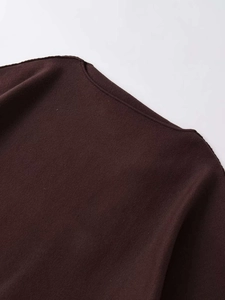 Close-up of dark brown knit top featuring a neat boat neck design and premium texture