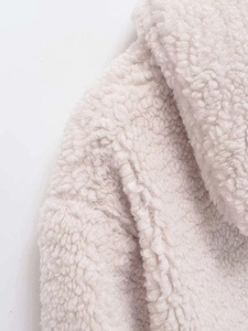 Close-up of the soft cream sherpa faux fur texture on this winter short jacket