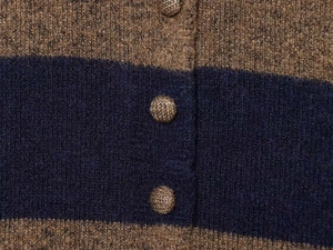 Detail of dark blue and tan striped knit sweater with textured woven buttons close-up