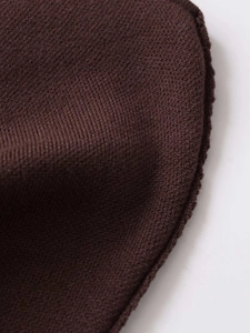 Detailed macro view of dark brown fine knit fabric with professional overlock stitching