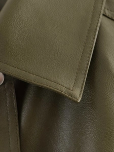 Detail of olive green faux leather texture and double-needle stitching on jacket