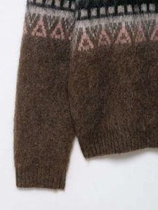 Detail of plush brown knit sweater featuring geometric Fair Isle patterns and fuzzy texture