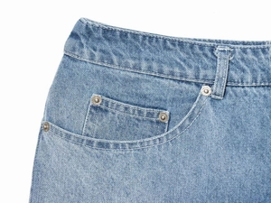 Detailed close-up of light blue denim waistline with metal rivets and coin pocket