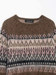 Macro detail of retro geometric jacquard pattern on a brown knit sweater fabric