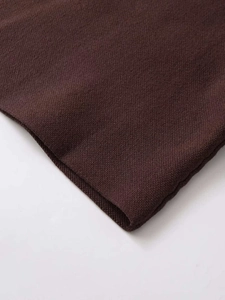 Detailed view of dark brown knitted fabric texture with professional edge stitching seams