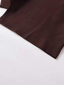 Close-up of the dark brown knitted fabric texture and fine stitching on the garment hem