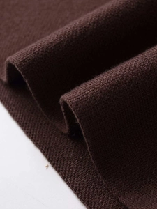Macro close-up of dark coffee knitted fabric texture with soft ribbed details and weave