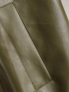 Detail of olive green faux leather with textured litchi grain and precise stitching details