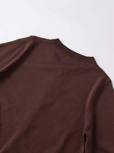 Detail view of the ribbed round neckline and soft texture of a brown knit cardigan